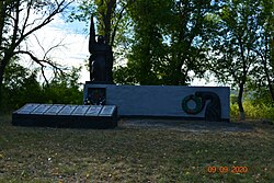 A mass grave of Soviet soldiers and a memorial sign in honour of fellow villagers