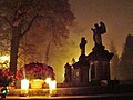 All Saints' Day at a cemetery in Sanok, Poland—flowers and lit candles are placed to honour the memory of deceased relatives.
