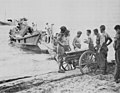 Australians with 3.7 inch howitzer dismantled before being loaded on a Japanese motor-driven barge which was captured at Milne Bay