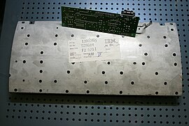 IBM Model M SpaceSaver Innenansicht, Rückseite: die Stahlplatte mittig und die Scancode-Platine oben. Auch zu sehen die ca. 50 Plastiknietköpfe, verteilt auf der Stahlplatte, Tastaturfolien und Tastengehäuse verbindend.