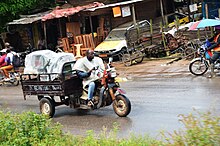 Photographie d'un homme au volant d'un véhicule.