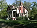 Free-standing white house with porch on left and red chimney