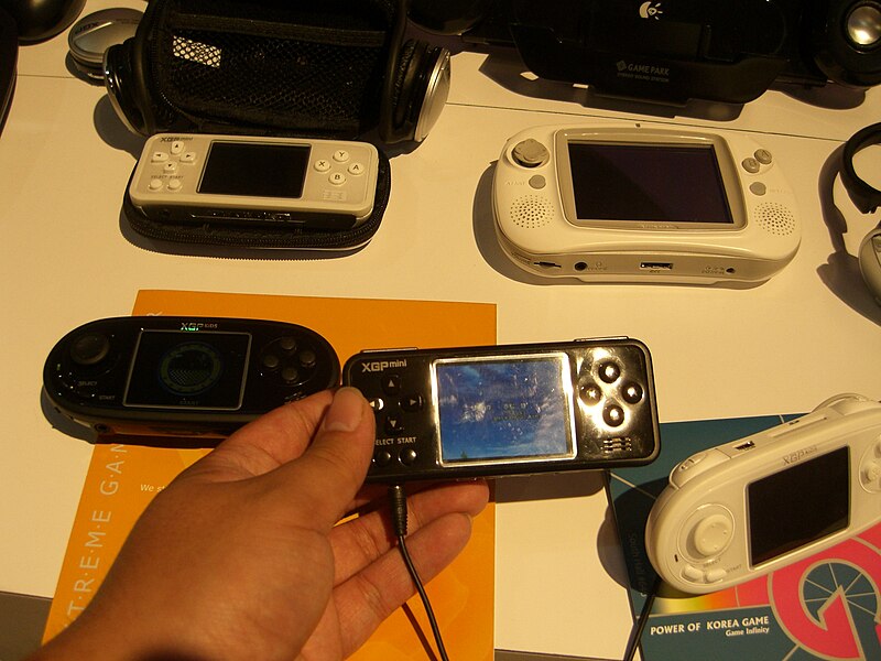 An XGP mini prototype next to other XGP consoles and a GP32 at E3 2006.