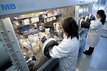 This is a photograph of researchers working with glove boxes at the Institute for Photonics and Advanced Sensing.