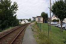 Voie unique, quai et ancien bâtiment. À droite le parking