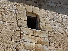 Ventana del siglo XV donde se ven los agujeros de la reja arrancada