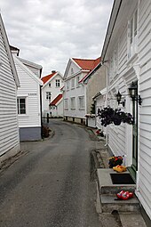 Foto einer engen Gasse, die von weißen Holzhäusern gesäumt ist