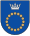 A coat of arms depicting a circle for which the boundary is itself made up of beige circles all under a silver crown on a blue background