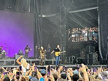 A color picture of singer Gwen Stefani and Blake Shelton performing their song "Purple Irises" live.