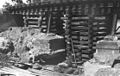 Underpinning the foundations of a railway bridge using a timber box crib to support the bridge. A completed concrete pad underpinning can be seen at the bottom right.]