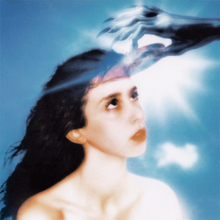 A gray hand with long fingernails pushing a CD into an opening in a bare-chested woman's head, with a blue sky and the sun shining in the background.