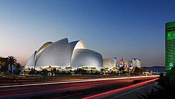 An abstract building with multiple dome-shaped elements on its exterior. A casino hotel is visible in the background.