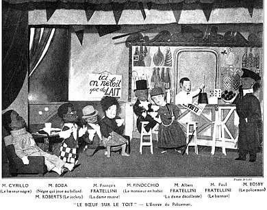 stage scene in a bar with characters wearing large cardboard heads