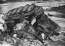 An upside down tank lying on a snowy ground