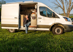 Solo female vancamper sitting with a cup of coffee