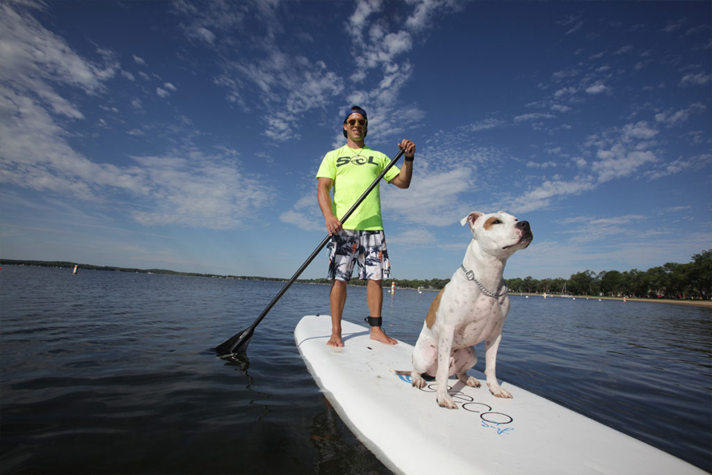 Man and dog on a standup paddle board