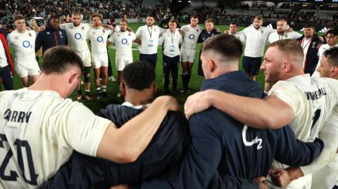 England players stand in a huddle