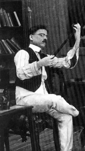 Dadasaheb Phalke, examining a strip of film