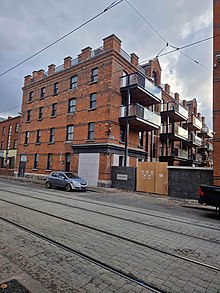 Re-developed social housing block with new brick work, windows, and balconies.