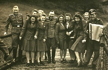 Men and women in uniform smiling and posing with musical instruments