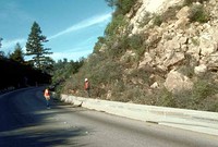 State Route 1 collapsed near Watsonville with Loma Prieta Peak visible in background (left) and landslide debris blocking both eastbound lanes of Highway 17 near Summit Road