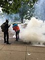 Protesters attempting to move gas canisters away from crowds on May 30 in Denver.