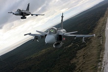 Three-quarter bottom view of two jet aircraft inn flight against a blue sky