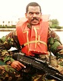 An NCO of the Bermuda Regiment armed with a General Purpose Machine Gun, aboard a Rigid Raider.