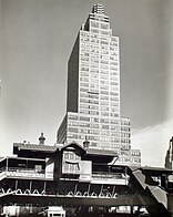 Tall green building with the words "McGraw-Hill" across the top floors, with a taller glass building behind