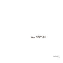 The words "The Beatles" embossed on a plain white background, with a serial number in the lower right.