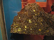 Polished slices of the stony-iron Esquel pallasite: at the Canadian Museum of Nature (left), at the American Museum of Natural History (middle) and encased yellow-green olivine crystals in the iron-nickel matrix are clearly visible (right).