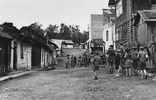 People and buildings with an unpaved street