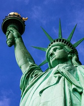 The Statue of Liberty, a large teal bronze sculpture on a stone pedestal