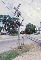 Two examples of WRRS Autoflag #5 "center harp" wigwag signals, (left): on a CN&W crossing in Wisconsin, July 1982. (right): on Devil's Lake, Wisconsin, September 2005. These signals were retired in 2012.