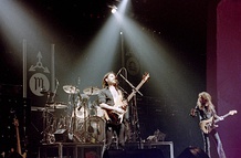 Two lineups of Motörhead performing live in 1982 (top) and 2013 (bottom).