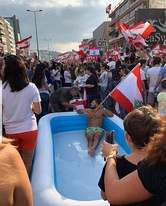 Protesters in front of the Grand Serial, Beirut, carrying a sign that reads "No to Sectarian Rule". 23 October 2019.