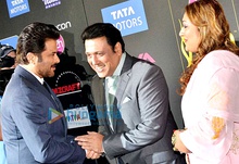 Govinda and Anil Kapoor shake hands, as Govinda's wife looks on