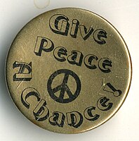 A "Give Peace a Chance" pin, likely a reference to the 1969 John Lennon song