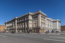 A very large, three-story tall stone building in early 18th-century style, with many narrow windows