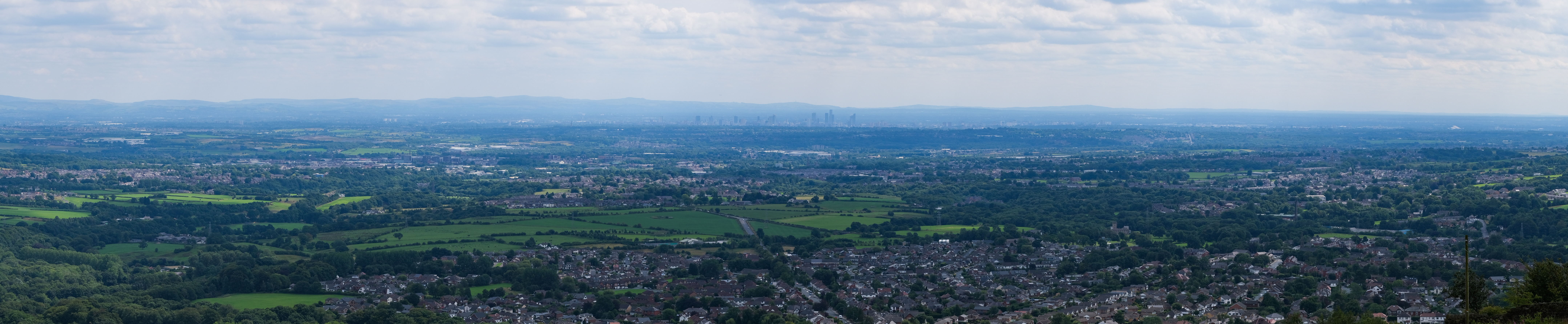  A view over Greater Manchester from the Peel Monument. The county is heavily urbanised and consists of vast built up areas and many settlements, fringed by sparsely populated countryside such as the West Pennine Moors.