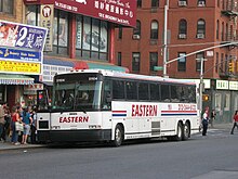 Passengers boarding a bus on a city street in warm weather