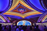 From top left to bottom right (a) A craftsperson sculpting the face of the sculpture-idol; (b) Durga Puja pandal decorations in Kolkata; (c) Interior decorations of a pandal; (d) Street lights installed during the festivities.