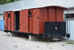 Photograph of a restored train car, with its sliding door open, used to transport Slovak Jews