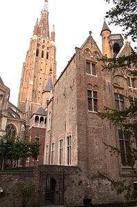 Estilo flamenco en ladrillo en Brujas, Bélgica, con la alta torre de la iglesia de Nuestra Señora