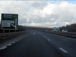 Road signs showing spellings of the village name.