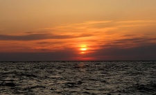 Sunlight shining upon two different sides of the U.S. state of New Jersey. Sunrise on the Jersey Shore at Spring Lake, Monmouth County (above), and sunset on the Shore at Sunset Beach, Cape May County (below). Both are filtered through high stratus clouds.