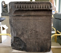 Slab of Psamtik I. The king kneels and makes offerings to fearsome-looking deities, including a double-headed bull god and a snake. From Alexandria; originally from the temple of Atum at Heliopolis, Egypt. British Museum