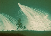 Night time air burst of white phosphorus as seen through night vision optics.