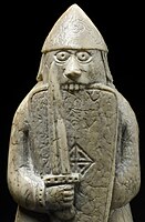 Different rook pieces from the Lewis chessmen, depicted as a warrior biting his shield.