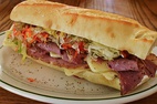 Examples of fast food (left to right, top to bottom): Cheeseburger, soft drink, french fries, pizza Margherita, hot dog, fried chicken, submarine sandwich, and donuts.